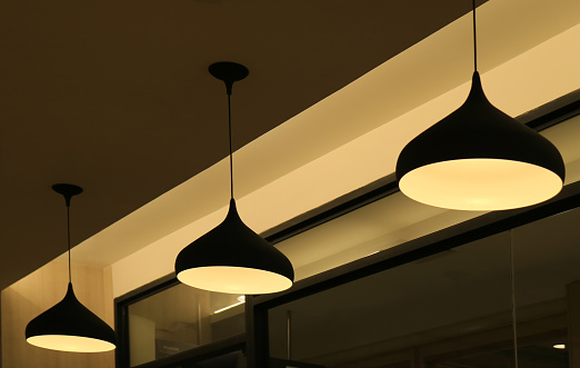 Three ceiling pendant lampshades lighting up the warm light