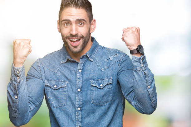 istock Young handsome man over isolated background celebrating surprised and amazed for success with arms raised and open eyes. Winner concept. 1084252232