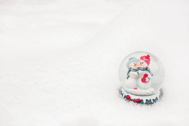 istock Christmas snow globe with two snowman on the snow 1084269200