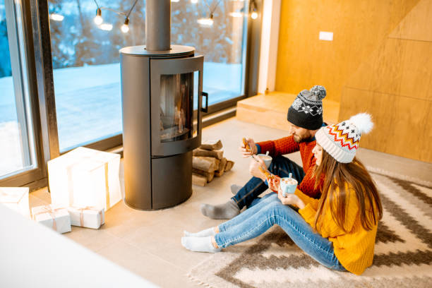 istock Couple with hot drinks near the fireplace during winter time 1084272092