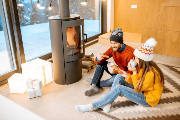 istock Couple with hot drinks near the fireplace during winter time 1084272138