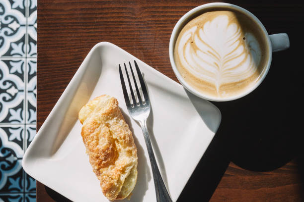 istock Latte with Art and Cuban Cheese Roll for Breakfast with Warm Sun 1084276902