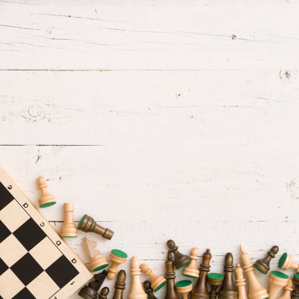 istock Wooden chess figures and chess board on white table background. Top view. 1084278456