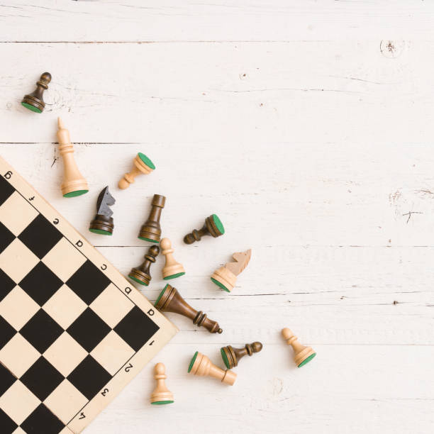 istock Wooden chess figures and chess board on white table background. Top view. 1084278808