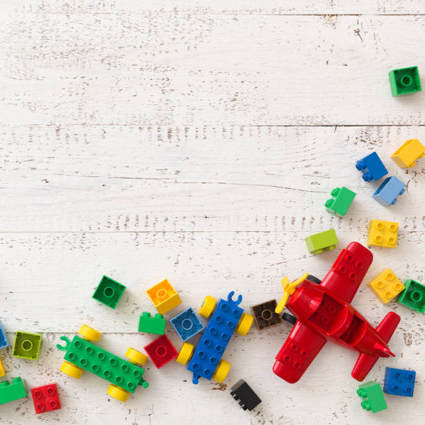 istock top view on white wooden table background with colorful plastic toy bricks and details. 1084278972