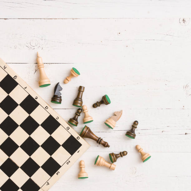 istock wooden chess figures on white table background. Top view. 1084279188