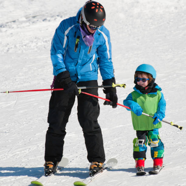 istock Father And Son Skiing On Snow Covered Field During Winter 1084282286