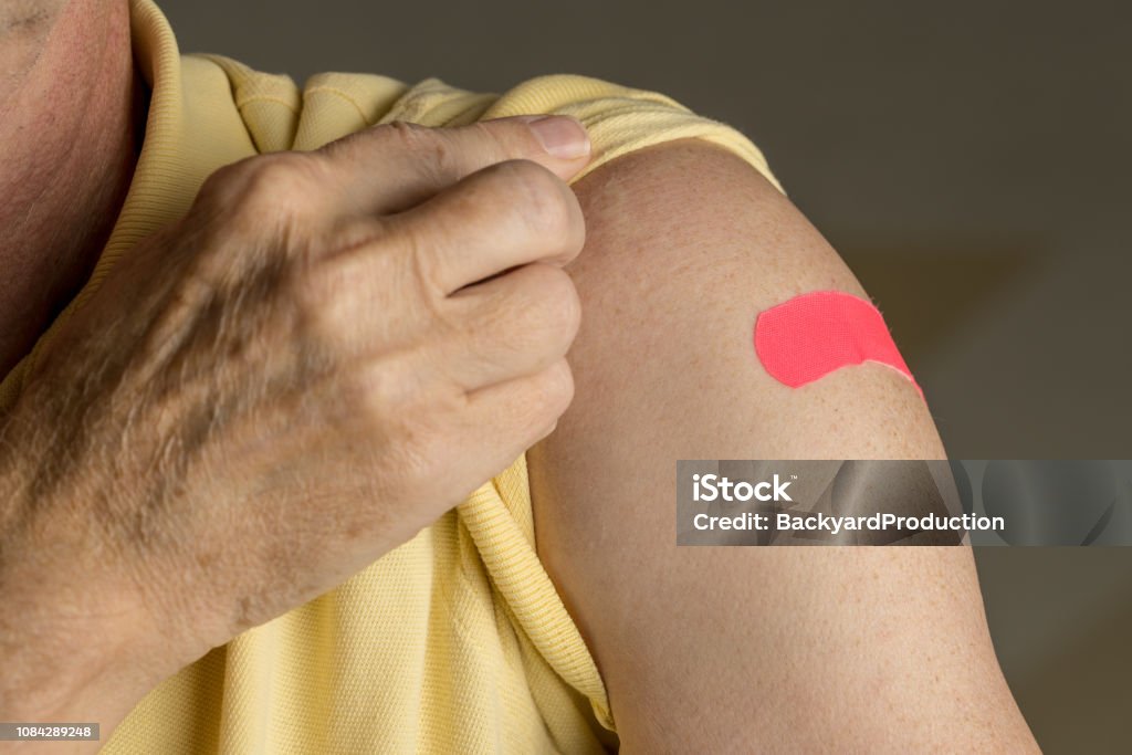 Último homem segurando a camisa após a injeção da gripe - Foto de stock de Vacina de Gripe royalty-free