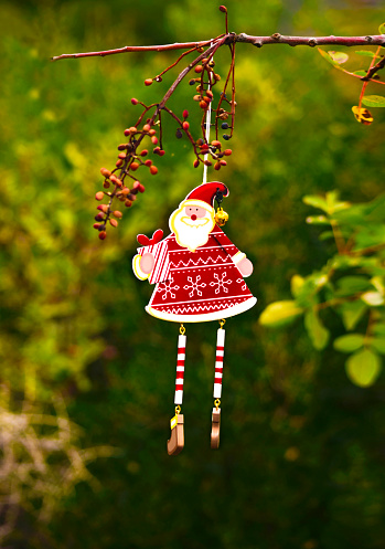 Santa Claus with christmas gift. wooden doll hanging on branch. Merry Christmas and New Year concept