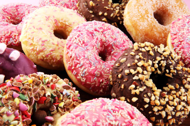 istock assorted donuts with chocolate frosted, pink glazed and sprinkles donuts 1084294202