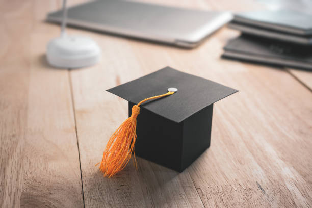 istock Construction paper craft graduation hat on wood desk 1084294216
