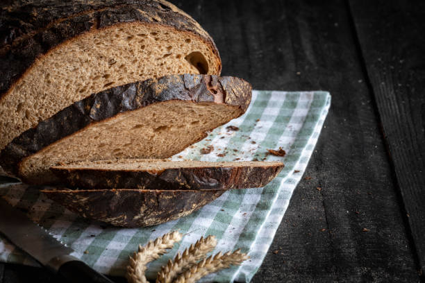 istock Sliced brown bread fresh baked on a kitchen towel 1084315550