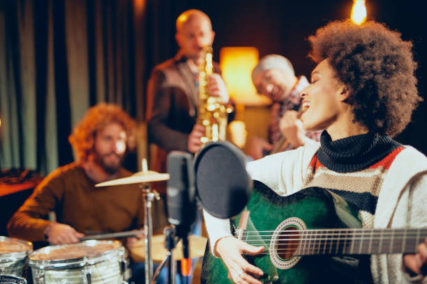 istock Mixed race woman singing and playing guitar. 1084322258