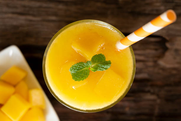 istock Mango smoothies yellow colorful fruit juice milkshake blend beverage healthy high protein the taste yummy In glass drink to lose weight drink episode morning on a wooden background from top. 1084327274
