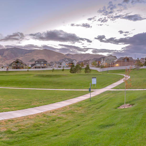 istock Pathway on lawn with homes and mountain background 1084329476
