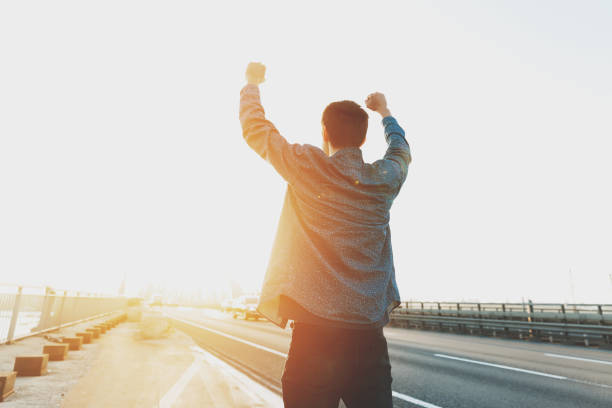 istock Happy man is standing with his arms raised up 1084333702