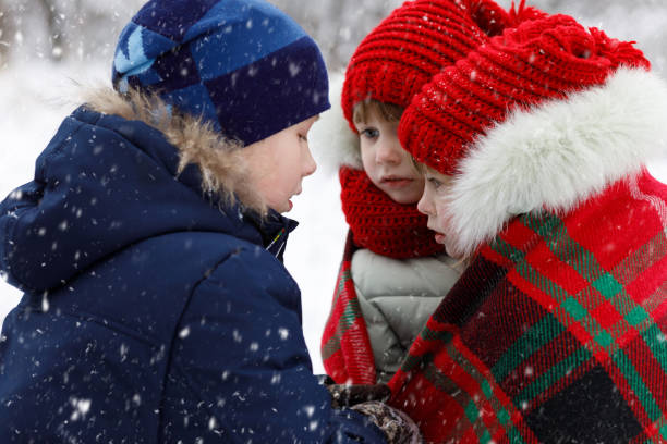 istock A brother is covering sisters twins with a plaid. 1084334534