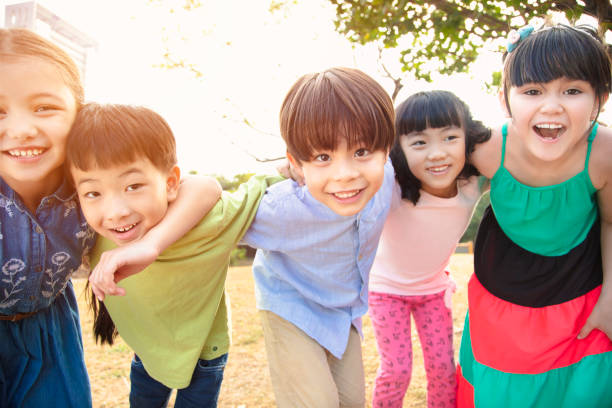 happy Multi-ethnic group of schoolchildren in park - fotografia de stock