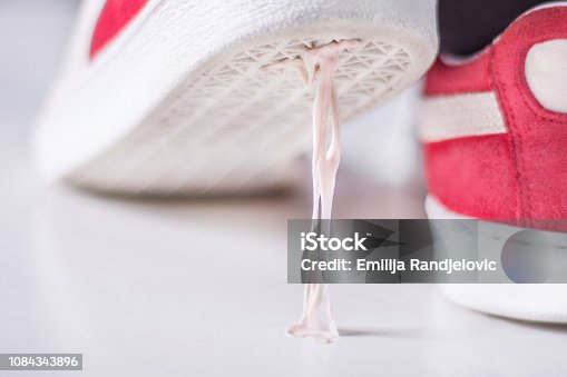 istock Sneakers stepping in chewing gum on white surface 1084343896