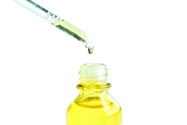 istock Dropping serum collagen moisturizer of face into clear yellow bottle soft light background. Protector skin Treatment facial essence oil, Vitamin C. Beauty and spa Concept. 1084349010