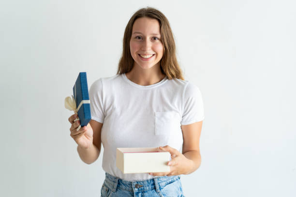 istock Smiling pretty young woman holding open gift box 1084353588