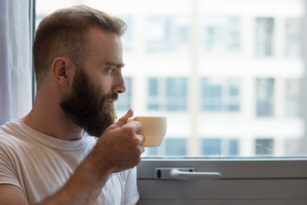 istock Close-up of pensive hipster man drinking coffee from cup 1084353924