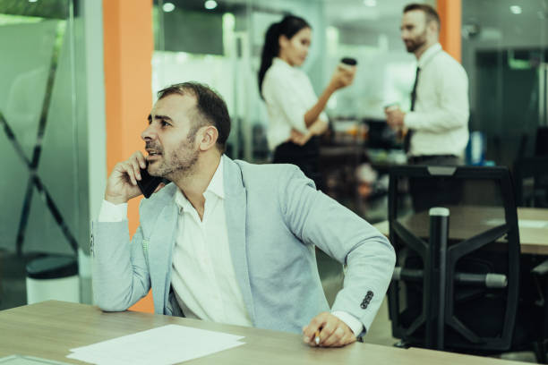 istock Focused business man talking on phone and working at desk 1084359964