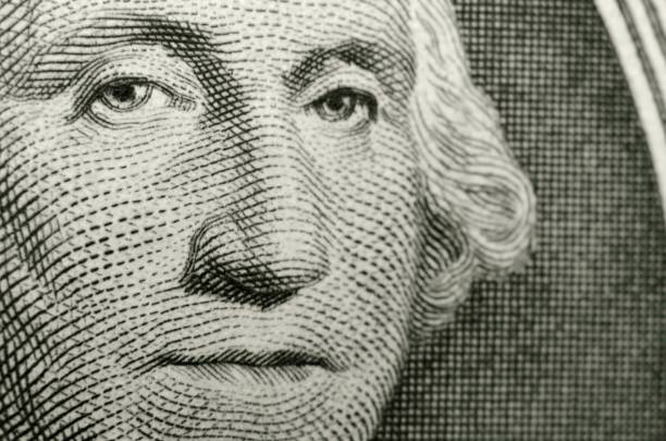 Slightly off axis, shallow focus close up, of president George Washington, from obverse of American one dollar bill. Selective focus creates a three dimensional effect to the portrait by Gilbert Stuart. george washington photos stock pictures, royalty-free photos & images