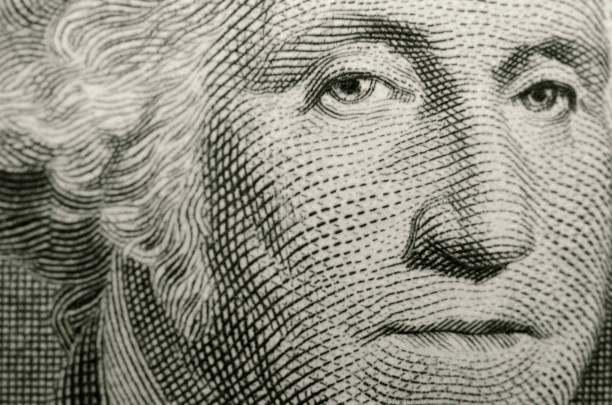 Slightly off axis, shallow focus close up, of president George Washington, from obverse of American one dollar bill. Selective focus creates a three dimensional effect to the portrait by Gilbert Stuart. george washington photos stock pictures, royalty-free photos & images