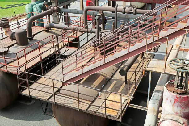 Photo of oxidize pipeline and stairs in a factory, closeup of photo