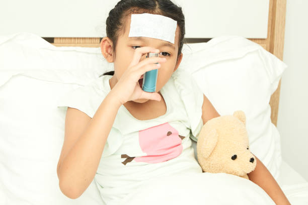 istock Little girl using asthma inhaler on blurred background 1084367244