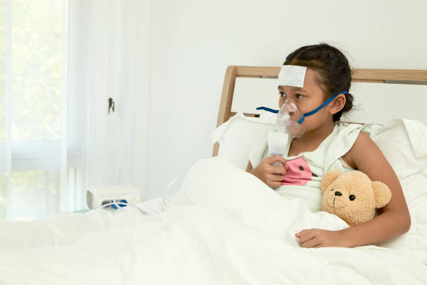 istock Little girl using asthma inhaler on blurred background 1084367258