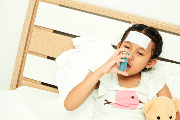 istock Little girl using asthma inhaler on blurred background 1084367266