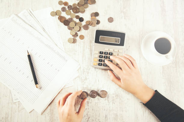 istock woman hand calculator and coins 1084368730