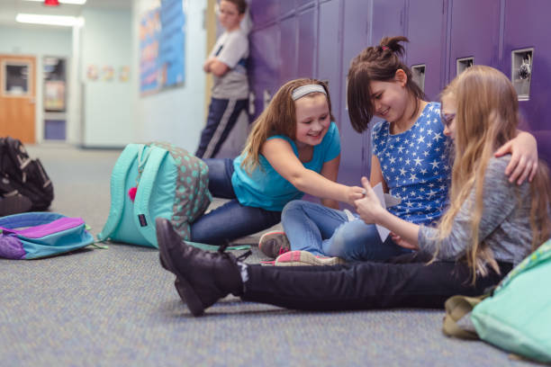 istock Two friends consoling their other friend at an elementary school 1084370778