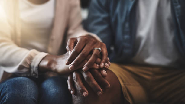 My love, my first source of comfort Cropped shot of a man and woman sitting on a sofa and holding hands couple holding hands stock pictures, royalty-free photos & images