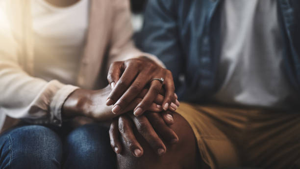 My love, my first source of comfort Cropped shot of a man and woman sitting on a sofa and holding hands married stock pictures, royalty-free photos & images