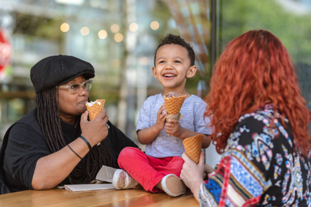 istock Two moms eat ice cream with their three-year old son 1084383604