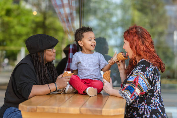istock Two moms eat ice cream with their three-year old son 1084383606