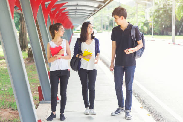 istock Young students talking and walking in school. Back to school concept. Education and study. 1084390982