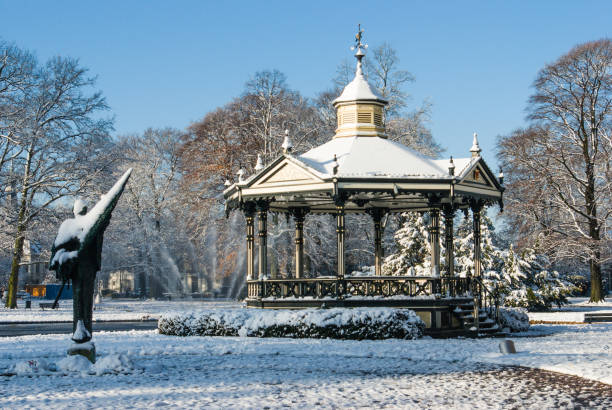 kiosque de la musique et la statue oranje parc apeldoorn dans la neige. - apeldoorn photos et images de collection