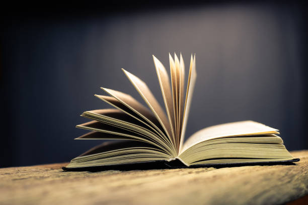 istock Open old book on a oak wooden table background of school board 1084399894