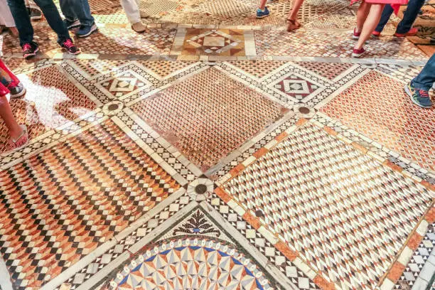 Photo of People walking inside of Venice buildings with ancient marble mosaic floor