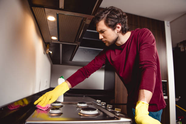 istock serious man in rubber gloves cleaning kitchen 1084405134