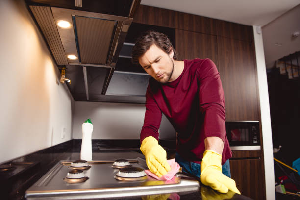 istock handsome man in rubber gloves cleaning kitchen at home 1084406162