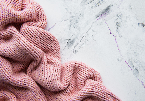 Pink knited sweater on a marble background
