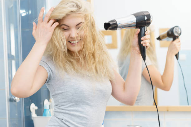 istock Blonde woman using hair dryer 1084422338