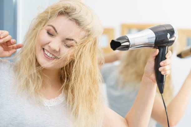 istock Blonde woman using hair dryer 1084423438