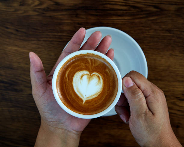 istock Hands holding coffee cup,heart on coffee cup and woman nails 1084430524