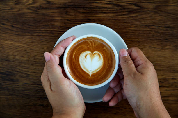 istock Hands holding coffee cup,heart on coffee cup and woman nails 1084430568